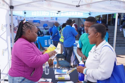 NSF official engaging with learners at exhibition stall.